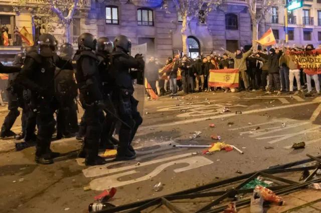 Manifestantes frente a un grupo de policías antidisturbios.