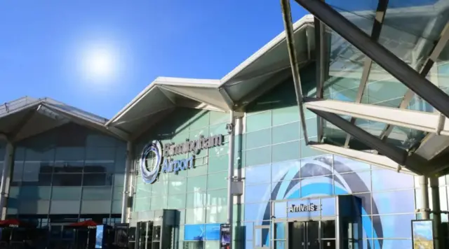 A large glass entrance to an airport with the words Birmingham Airport above the door