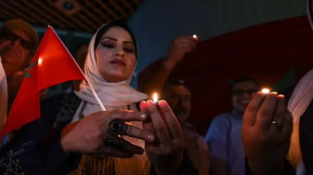 أشخاص يشعلون الشموع