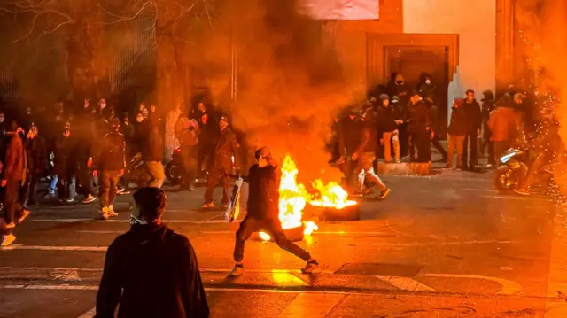 İranlılar, 9 Ocak 2026'da Tahran'da düzenlenen bir protesto sırasında bir sokağı trafiğe kapatarak toplandı.