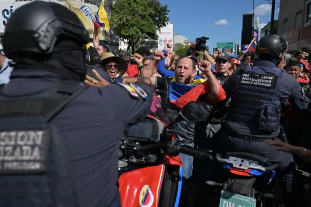 Venezuela'da bir eylemcinin polisle karşı karşıya geldiği görülüyor.