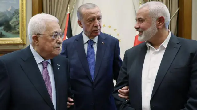 Erdoğan, Abbas ve Haniye'nin Cumhurbaşkanlığı Külliyesi'nde fotoğrafı. Erdoğan, iki Filistinli liderin ortasında ve kollarına girmiş şekilde poz veriyor.