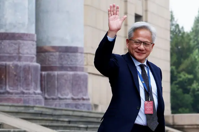 Nvidia CEO Jensen Huang waves as he prepares to depart the Great Hall of the People on May 14, 2026 in Beijing
