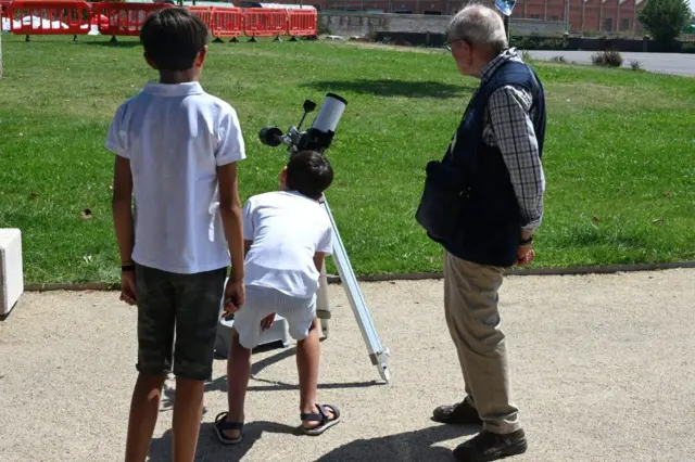 Jovens se revezam para observar o céu com um telescópio em León, no noroeste da Espanha, horas antes do fenômeno
