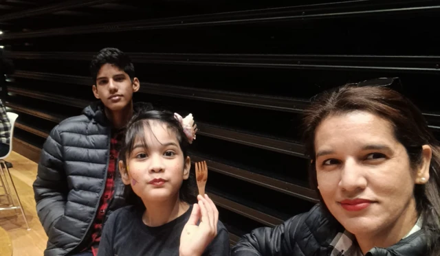 Francis Salazar, 46, com seus filhos e um fundo escuro