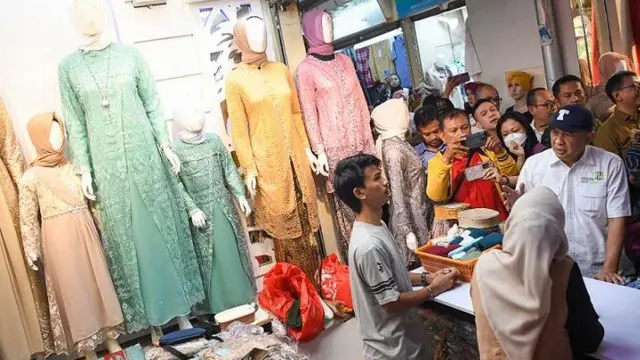 Menteri Koperasi dan UKM Teten Masduki (kanan) berbincang dengan pedagang saat berkunjung ke Pasar Tanah Abang Blok A, di Jakarta, Selasa (19/9/2023). 