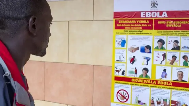 Un homme consultant une affiche sur Ebola.