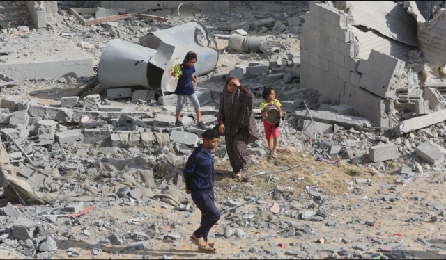 ਗਾਜ਼ਾ ਵਿੱਚ ਇਜ਼ਰਾਈਲ ਦੇ ਹਮਲੇ ਤੋਂ ਬਾਅਦ ਮਲਬੇ ਵਿੱਚ ਖੜ੍ਹੇ ਲੋਕ
