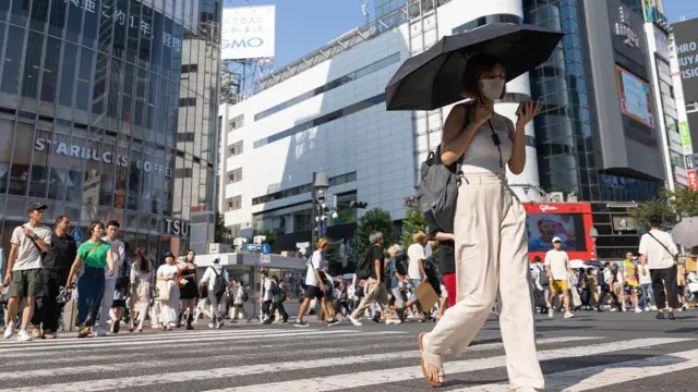 一名女子走在東京的斑馬線上