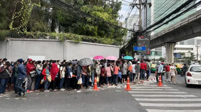 နိုင်ငံကူးလက်မှတ် (ပတ်စပို့စ်) လုပ်ဖို့ ဘန်ကောက်မြို့က မြန်မာသံရုံးရှေ့မှာတန်းစီစောင့်ဆိုင်းနေရတဲ့မြန်မာတွေ