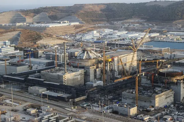 Akkuyu santralindeki reaktör inşaatının uzaktan çekilmiş fotoğrafı. Neredeyse tamamlanan ilk reaktörün kubbesi görünüyor. Etrafında ise vinç ve iskeleler gibi inşaat malzemeleri var.