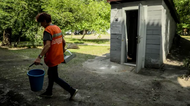 Працівниця комунального підприємства проходить повз укриття у Києві.