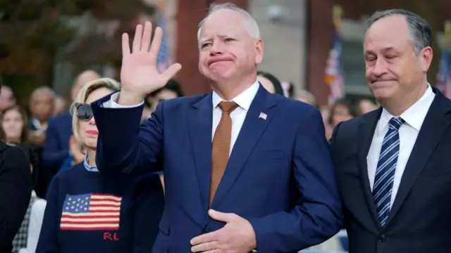 Tim Walz (uzamuye ikiganza), ari kumwe na Douglas Emhoff umugabo wa Kamala Harris, bari mu bari aho