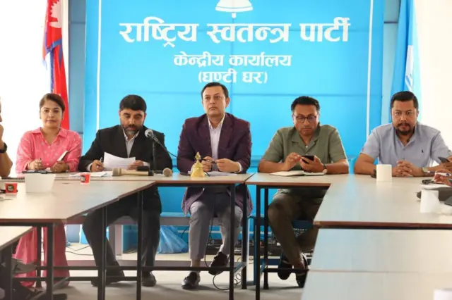 पार्टीको झण्डाअगाडि बसेका रास्वपा नेताहरू