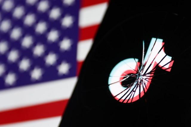 شاشة مكسورة تظهر شعار تيك توك أمام العلم الأمريكي