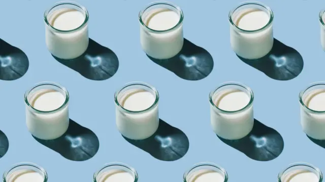 Soluk mavi bir arka plan üzerinde çapraz çizgiler halinde dizilmiş küçük kefir bardakları.