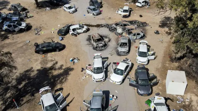 Burned out cars line the road at a music festival which was attacked by Hamas