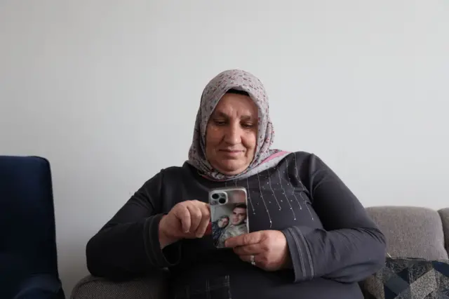 Aynur Tekedereli, telefonuna bakıyor. Telefonunun kapağında oğlunun resmi var.