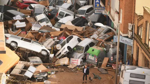 Idoso e cachorrocomo fazer apostas certas no futebolfrente a carros amontoados arrastados pela chuva