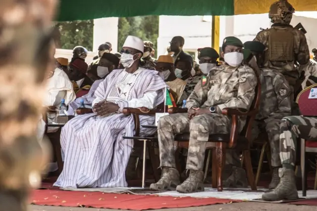 Le Premier ministre malien Choguel Kokalla Maïga (au centre à gauche) et le président malien de transition Assimi Goita (au centre à droite) attendent le défilé des milices lors de la cérémonie célébrant la fête nationale de l'armée, à Kati, le 20 janvier 2022