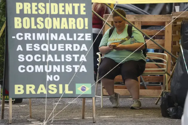 Imagem mostra faixa com os dizeres 'Presidente Bolsonaro! Criminalize a esquerda socialista comunista no Brasil' no acampamentocomo sacar na betsulBrasília