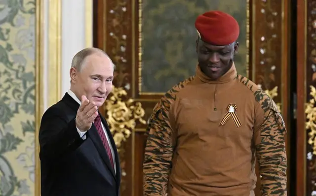 Le président russe Vladimir Poutine, en costume, accueille Ibrahim Traoré, en uniforme militaire, à Moscou le 10 mai 2025.