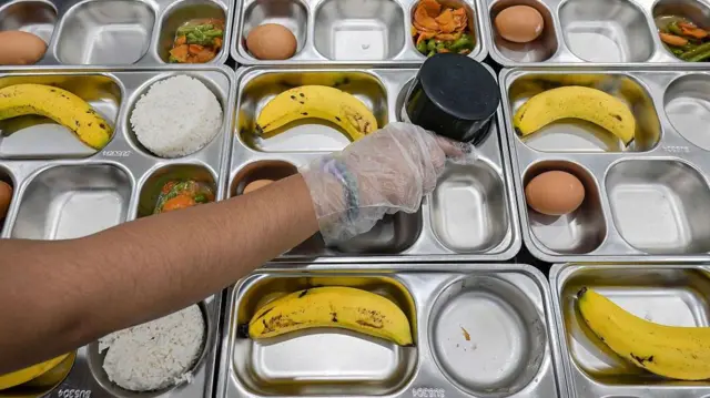 Gambar yang memperlihatkan petugas salah satu unit layanan makan bergizi gratis menyiapkan makanan untuk siswa SD dan SMP di Jakarta.