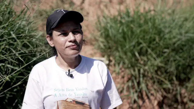 Débora dos Santos, uma mulherbet7k jogo42 anos, com chapéu preto e camiseta branca,bet7k jogofrente a barranco na ocupação