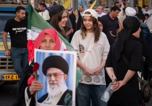 Tahran'da Hamaney lehine yapılan bir gösteride hamaney'in fotoğrafını elinde tutan bir kadın. 