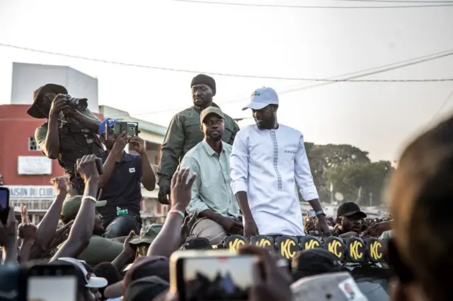 Le Président Bassirou Diomaye Faye en blanc et le Premier ministre Ousmane Sonko en vert olive lors de la campagne électorale pour la présidentielle de mars 2024.