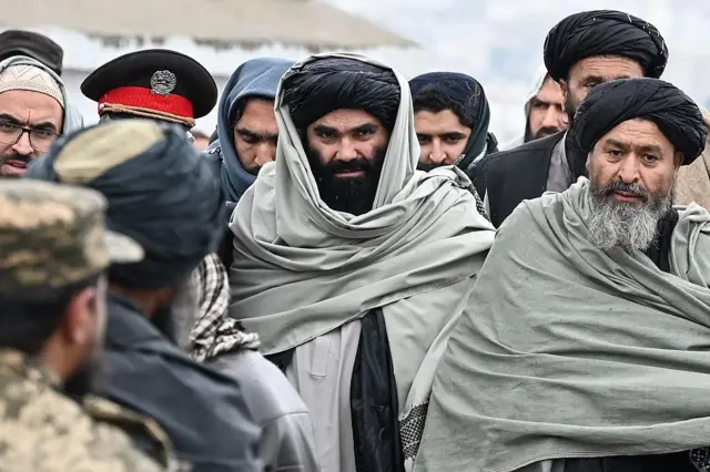  TOPSHOT - Sirajuddin Haqqani (C), Interior Minister of Afghanistan's Taliban government arrives to attend a mass funeral held for victims of a Pakistani air strike on a drug rehabilitation centre, at the Badam Bagh Hilltop in Kabul on March 18, 2026. The Taliban authorities have said that around 400 people were killed and more than 200 wounded on March 16 night, in the deadliest attack yet in the recent upsurge in violence between the two neighbours. (Photo by Wakil KOHSAR / AFP via Getty Images)
