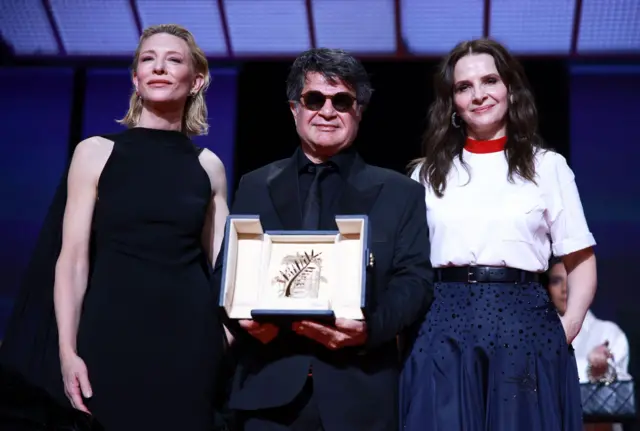 جعفر پناهی در کنار ژولیت بینوش، رئیس هیئت داوران بخش مسابقه کن (سمت راست) و کیت بلانشت،‌ بازیگر 