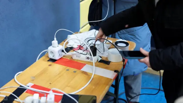 Стіл на ньому заряджаються мобільні телефони 