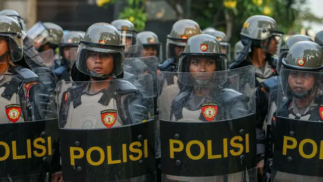 Petugas polisi berjaga dan menghalau massa yang melakukan demonstrasi di depan Mapolda Metro Jaya di Jakarta, Indonesia, pada 29 Agustus 2025.