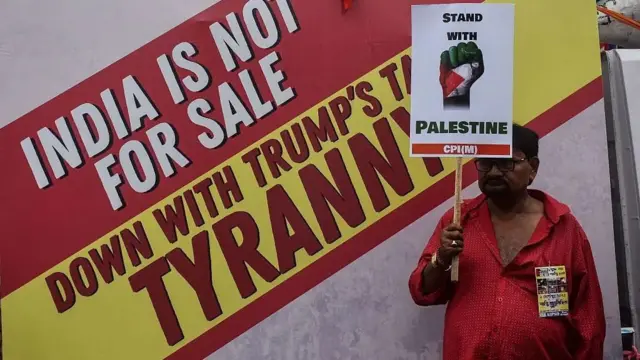 رجل في الهند يحمل لافتة تعبر عن وقوفه إلى جانب فلسطين 