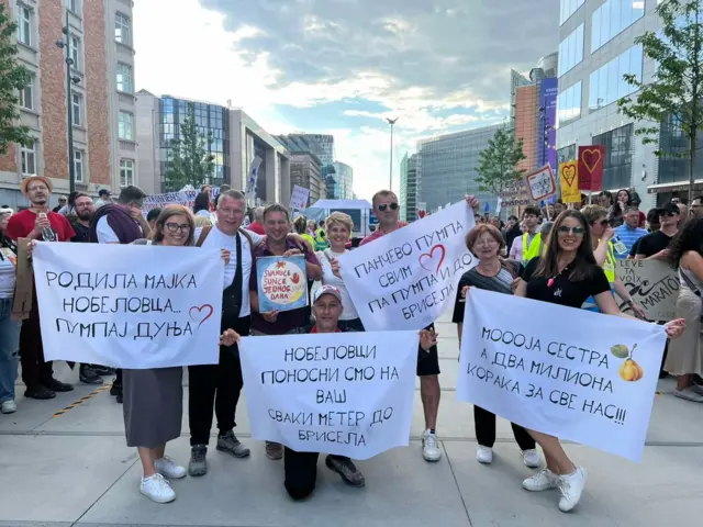 Muškarci i žene drže transparente u rukama