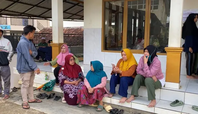 Keluarga yang menunggu kabar penemuan jenazah kerabatnya yang tertimbun longsor.