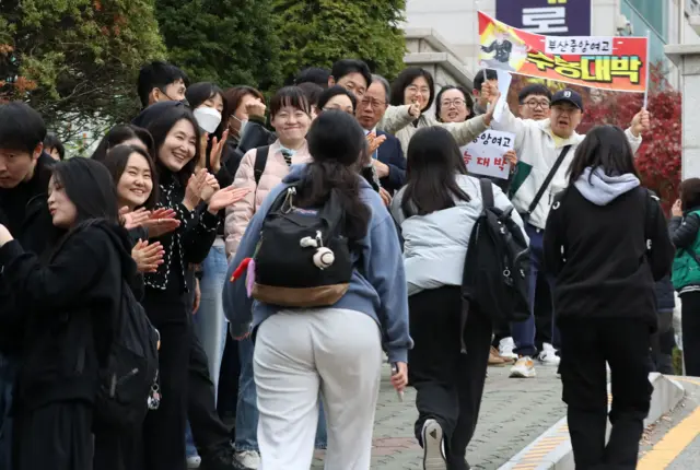 부산 연제구 연제고등학교 앞에서 수험생들이 교사 등에게 응원을 받으며 고사장으로 향하고 있다