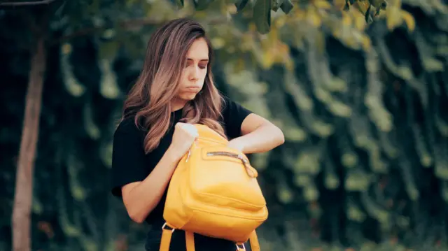 Mujer buscando algo en su cartera