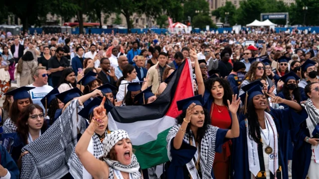تجمع انبوه دانشجویان معترض در حمایت از غزه، چفیه و پرچم فلسطین به دست دارند