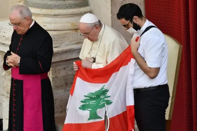 صورة أرشيفية للبابا فرنسيس وهو يحمل علم لبنان، ويصلي من أجل لبنان في باحة سان دامازو بالفاتيكان عام 2020
