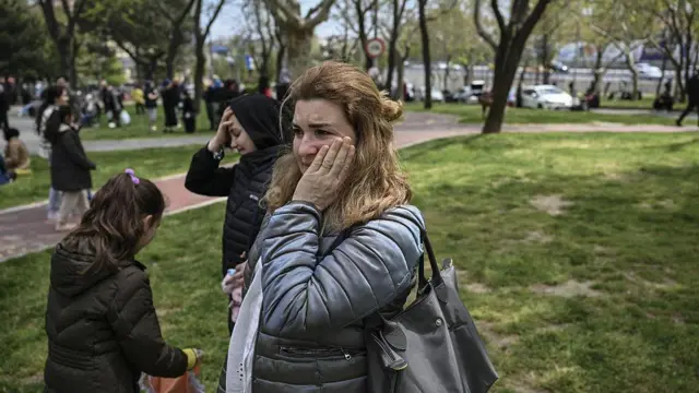İstanbul'da park alanında iki tane endişeli kadın ellerini kafalarına ve yüzlerine koyarak bekliyor.