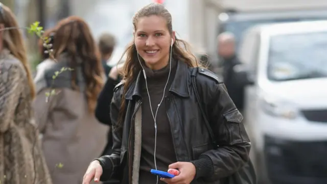 Una mujer con auriculares con cable.