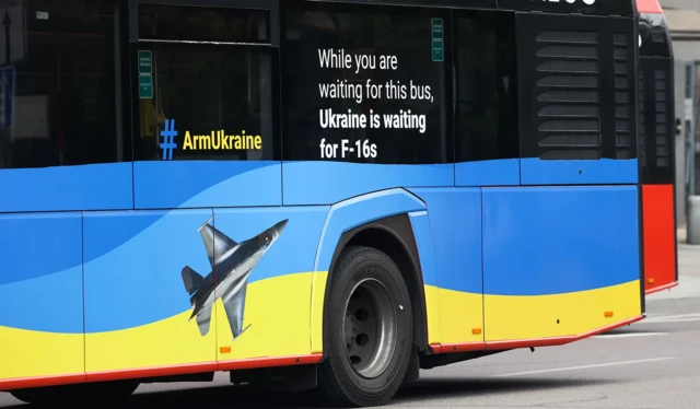 Un message sur ce bus lit : "pendant que vous attendez ce bus, l'armée ukrainienne attend ses F-16"