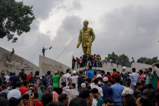 ผู้ประท้วงยังพยายามรื้อรูปปั้นนายชีค มูจิบูร์ เราะห์มาน ผู้เป็นพ่อของนางฮาสินา ซึ่งเป็นบิดาผู้ก่อตั้งประเทศ
