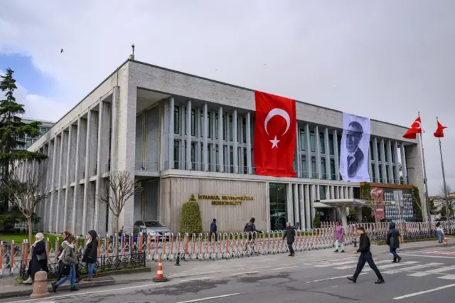 İstanbul Saraçhane'deki İstanbul Büyükşehir Belediyesi binası. Önünde insanlar yürüyor. 