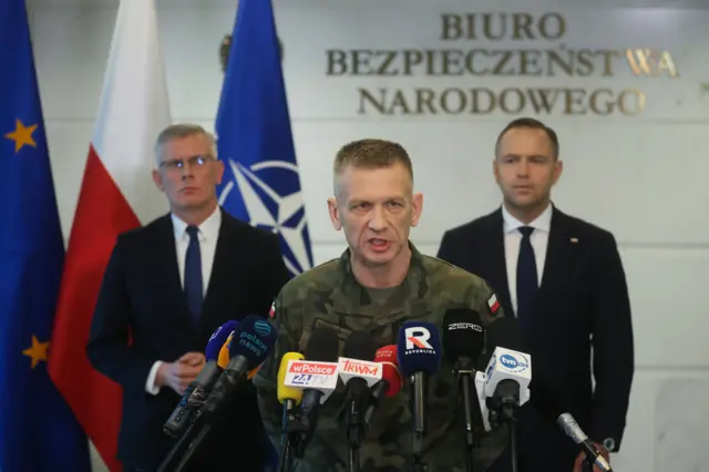 Президент Польщі Кароль Навроцький (праворуч) та керівник Бюро національної безпеки Славомір Ценцкевич (ліворуч) слухають виступ генерал-майора Адама Ржечковського на пресконференції у Варшаві