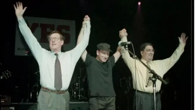 Bono no palco com John Hume e David Trimble