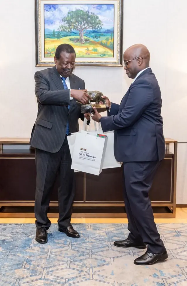  Minisitiri w'ububanyi n'amahanga akaba n'a minisitiri ushinzwe ibikorwa bya leta muri Kenya Musalia Mudavadi (Ibumoso) ahana imifuka irimo impapuro z'amasezerano na Minisitiri w'ububanyi n'amahanga n'Ubutwererane w'uRwanda Olivier Jean Nduhungirehe