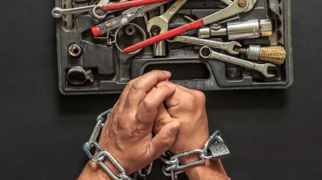 صورة تعبيرية لمفهوم الحق في الإصلاح يظهر فيها صندوق أدوات وخلفه يدا شخص مكبلتان